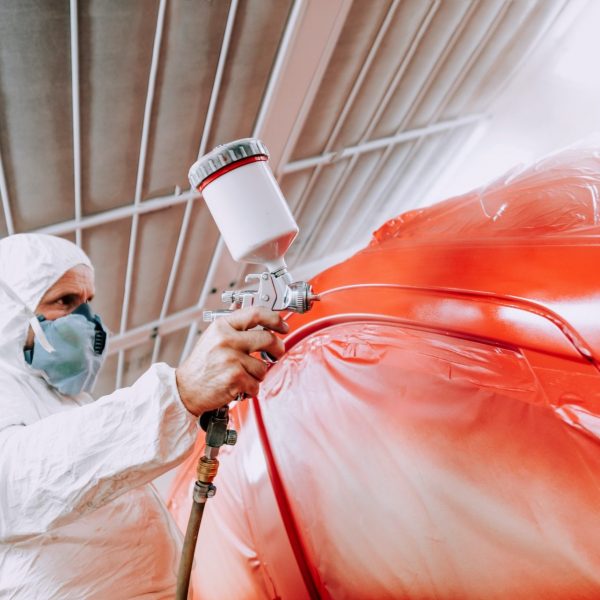 automotive-industry-mechanic-engineer-worker-using-spray-gun-and-painting-a-red-car-1-e1635932957111.jpg